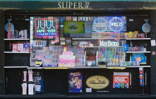 Super 7 kiosk filled with products and bright neon advertisements.