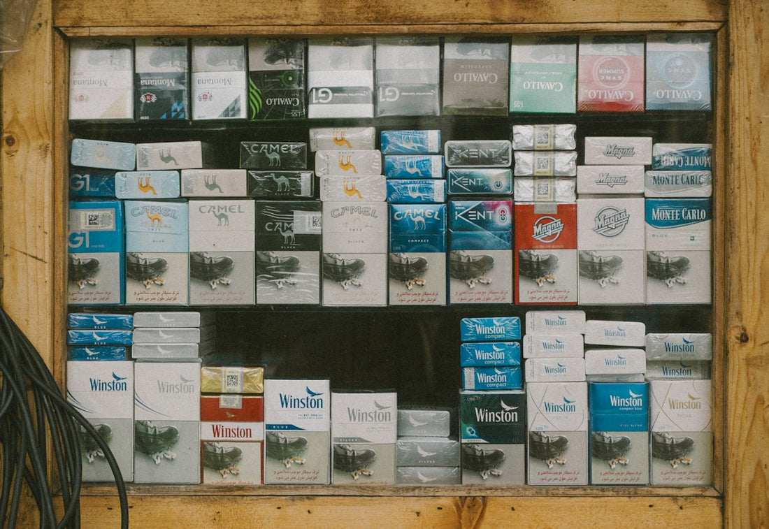 Various cigarette packs displayed behind a glass window